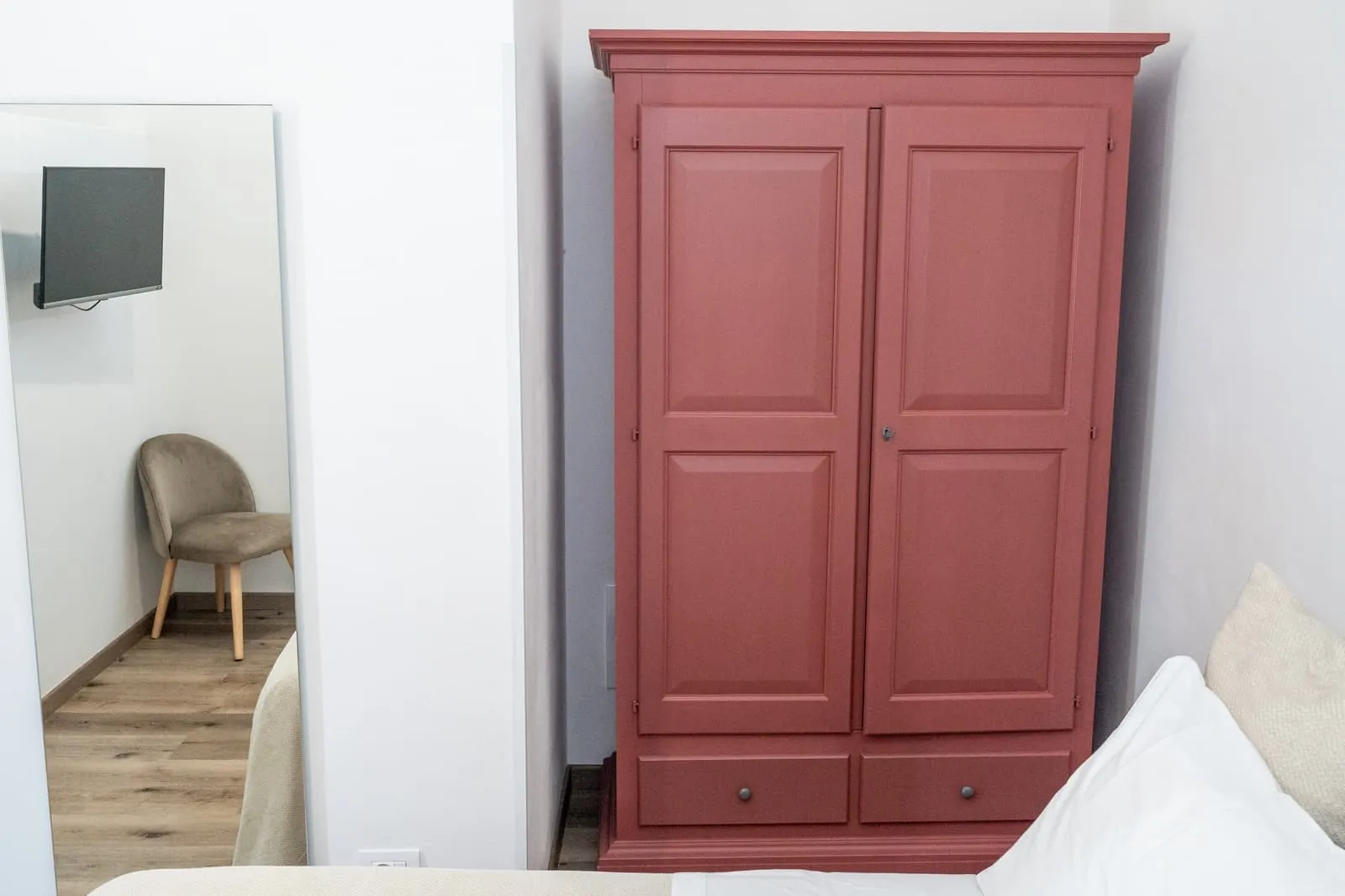 Camera Ciliegio con armadio rosso mattone, poltroncina in velluto e specchio a figura intera
