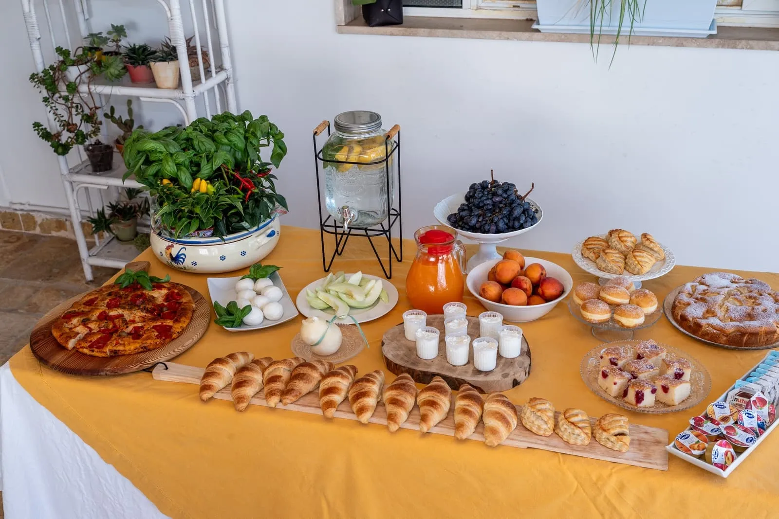 Tavola della colazione con torte, frutta, mozzarelle e focaccia fatte in casa