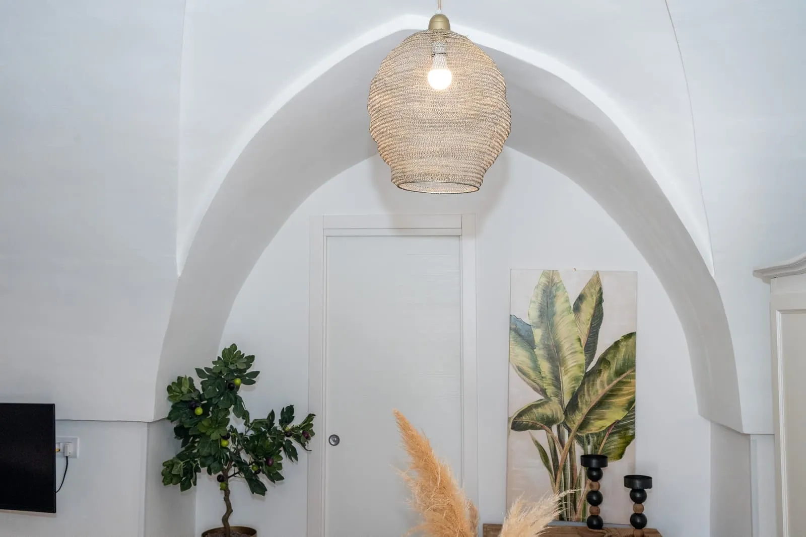 Arco a volta della Suite Fico con lampada in vimini e piante