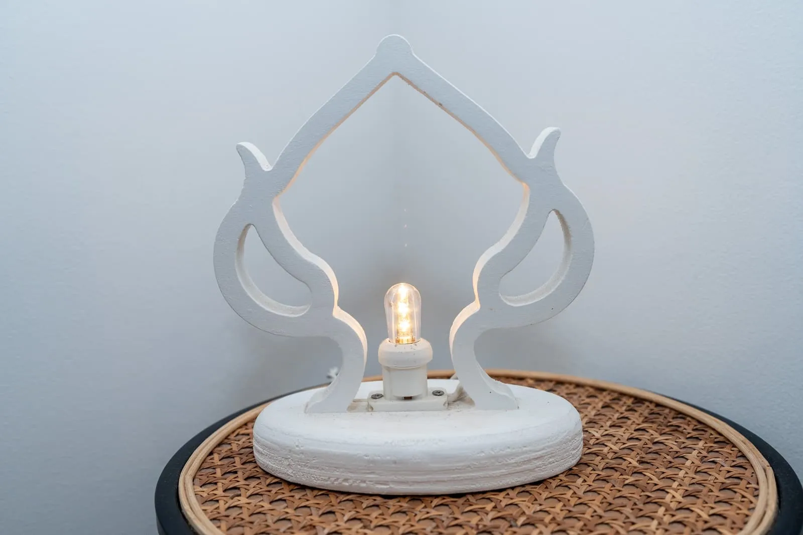 Lampada decorativa bianca su comodino in paglia di Vienna