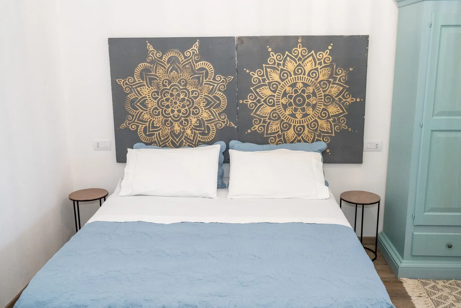 Camera Melograno con letto matrimoniale, testiera mandala dorata e armadio azzurro