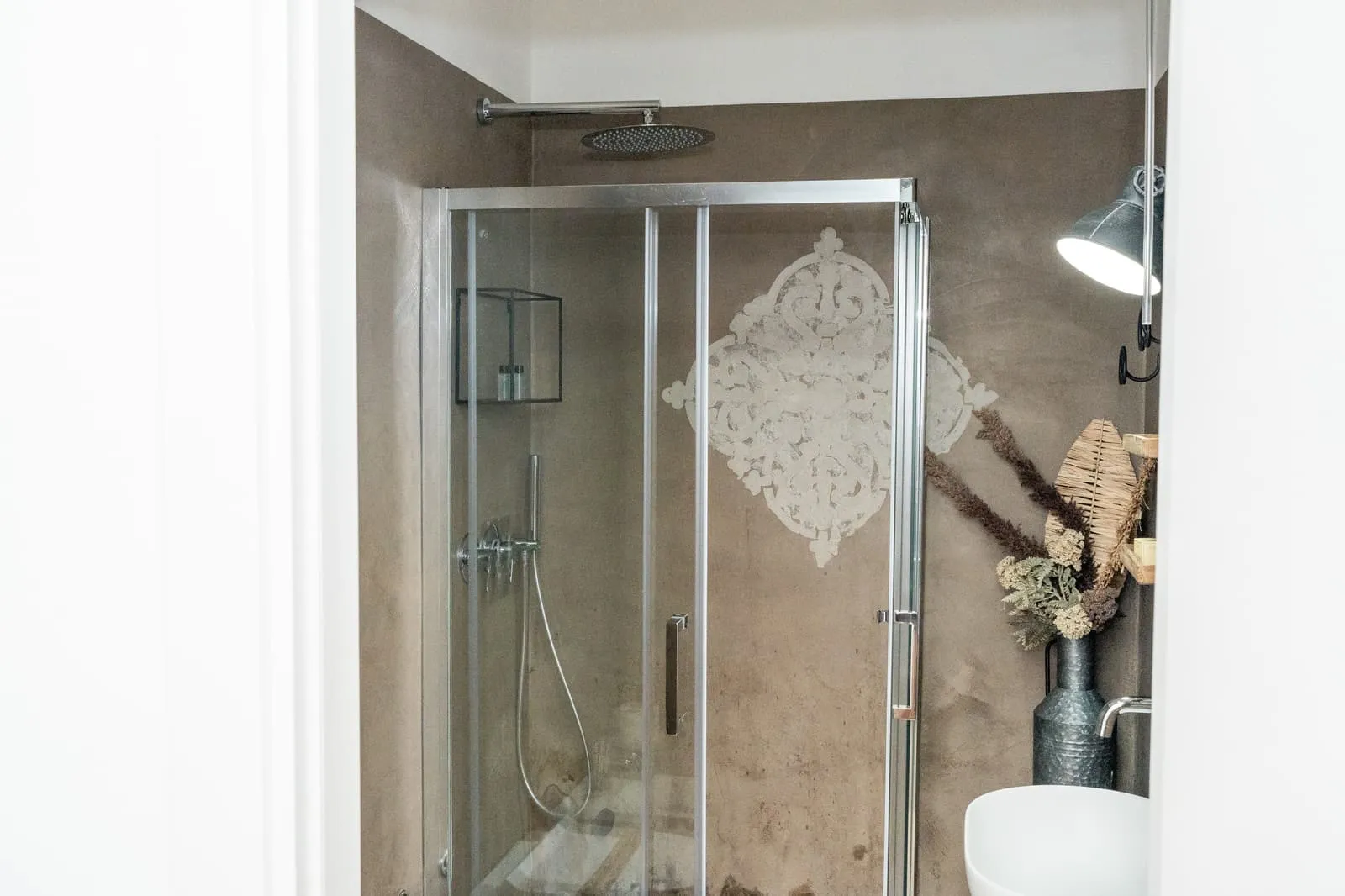 Doccia con decoro in stucco nel bagno della camera Melograno