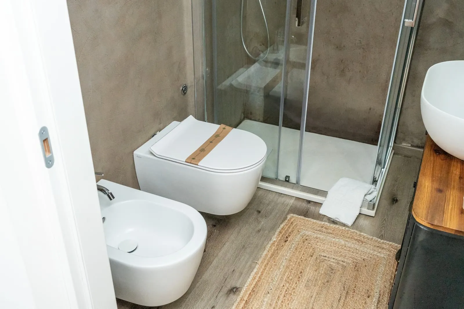 Bagno della camera Melograno con sanitari sospesi e tappeto in fibra naturale
